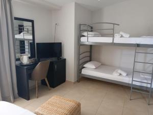 普雷韦扎Hotel MINOS的客房设有两张双层床和一张带电脑的书桌。