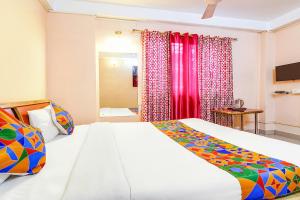 MātigaraFabHotel Oasis的卧室配有白色大床和红色窗帘