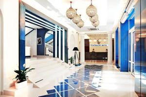 扎波罗热Teatralny Hotel的大堂设有蓝色的墙壁和黑白瓷砖地板。