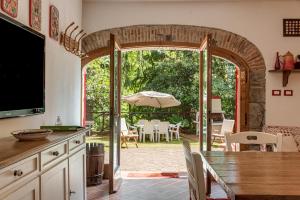 皮斯托亚Casale Il Ricavo的开放式厨房以及带桌子和遮阳伞的用餐室。