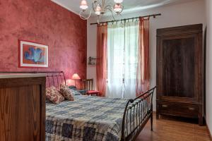 皮斯托亚Casale Il Ricavo的一间卧室设有一张床和红色的墙壁