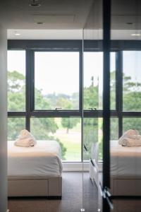 墨尔本Luxury Melbourne with Albert Park Views的带大窗户的客房内的两张床