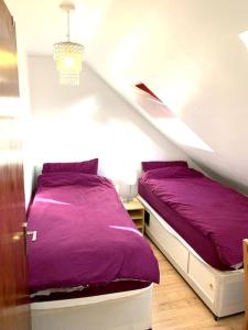 牛津A Comfortable Room in a Friendly Home in Headington, Oxford的阁楼上的卧室配有两张床