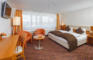 戈汀根希尔莫维瑞士优质酒店的酒店客房带一张床、一张桌子和椅子