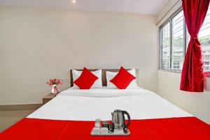 加尔各答GRG Vhyom Sky Palace Near Metro Station Kolkata的卧室配有带红色枕头的大型白色床