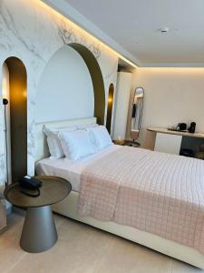 伊罗达Naiades Boutique Hotel - Adults Only的一间卧室配有一张大床和一张桌子