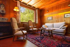 Le TourChalet La Remuaz - Happy Rentals的客厅配有沙发、椅子和桌子