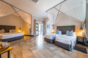 维多利亚瀑布Nkosi Guest Lodge的酒店客房设有两张床和一张桌子。