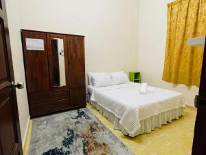哥打巴鲁Kota Bharu Homestay的一间卧室配有两张床和橱柜