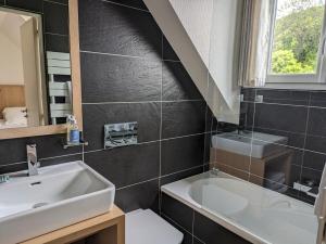 康卡勒Chambres d'hôtes Breizh Café的浴室配有盥洗盆和浴缸。
