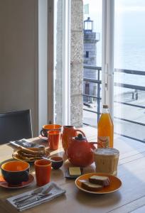 康卡勒Chambres d'hôtes Breizh Café的餐桌,带食物盘和一瓶果汁
