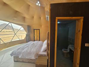 瓦迪拉姆Salma Desert Camp的一间卧室配有一张床,浴室设有窗户