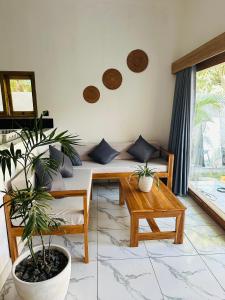 龙目岛库塔Santai Retreat的带沙发和一些植物的客厅
