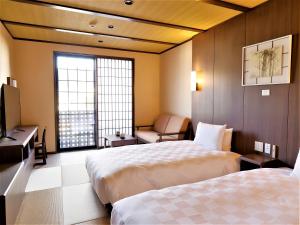箱根Hotel Morinokaze Hakone Sengokuhara的酒店客房设有两张床和窗户。