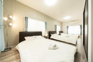武藏野23, Midoricho, Entire house, Capacity 6 people的一间卧室配有两张带白色床单的床