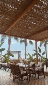 ErdemliAngel Beach Hotel Kızkalesi Mersin的一个带桌椅的庭院,棕榈树