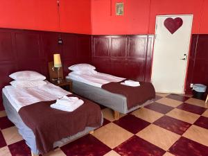 斯德哥尔摩Reimersholme Hotel的红色墙壁的客房内的两张床