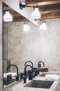 卡尼略L´Ovella Negra Mountain Lodge的浴室设有2个水槽和2盏灯。