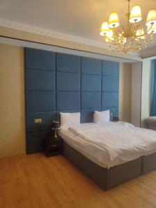 巴库Sherlock Gold Baku Hotel的一间卧室配有一张大床和蓝色床头板