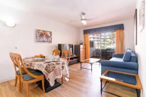 圣米格尔德阿沃纳Oceanfront 2 bedrooms Holiday Home in Tenerife South的客厅配有桌子和蓝色沙发