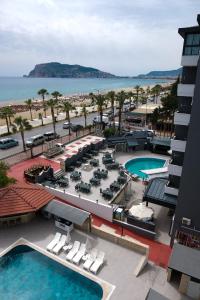 阿拉尼亚Kaila Krizantem Hotel的享有带游泳池和椅子的度假村景色
