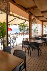 阿拉尼亚Kaila Krizantem Hotel的海滩上带桌椅的餐厅