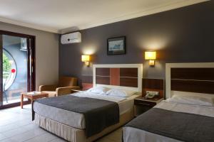 阿拉尼亚Kaila Krizantem Hotel的酒店客房,配有两张床和椅子