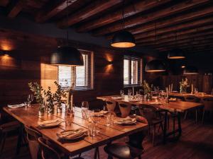 卡尼略L´Ovella Negra Mountain Lodge的餐厅设有木桌和椅子及灯