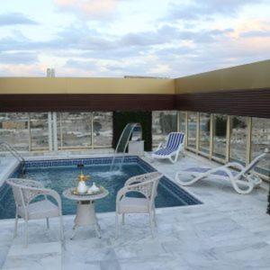 吉达Areen Hotel Airport的庭院设有游泳池、椅子和桌子。
