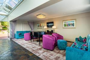 开普敦信号山旅舍的客厅配有紫色椅子和钢琴