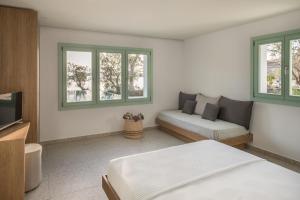 VourkarioKEAnõs的一间卧室配有一张床、一张沙发和窗户。