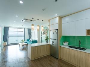 下龙湾Green Diamond Homestay Hạ Long的带冰箱的厨房和客厅