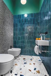 波兹南橘园公寓的蓝色瓷砖浴室设有卫生间和水槽