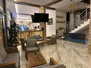 多布拉沃达Bosfor Hotel的大堂配有沙发和墙上的电视