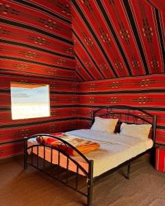 瓦迪拉姆Desert Bird Camp的红色墙壁的房间里一张床位