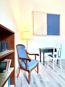 都灵ComeCasa near Piazza Vittorio 2 Bedrooms的客厅配有椅子和书桌