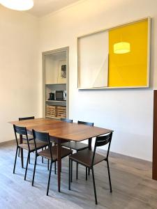 都灵ComeCasa near Piazza Vittorio 2 Bedrooms的一间带木桌和椅子的用餐室