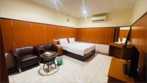 拉斯阿尔卡麦Lulu guest house的酒店客房配有一张床、一把椅子和一台电视。