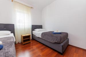 索利纳Apartments Stašić Katarina的一间卧室设有两张床,铺有木地板