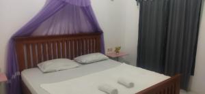 RiungMentos Bungalowz Riung的一间卧室配有一张大床和紫色窗帘