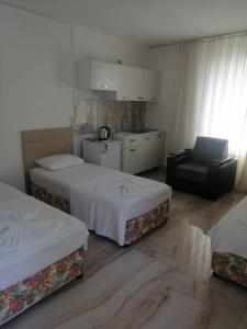 凯麦尔Kiriş Garden Hotel的酒店客房,配有两张床和椅子