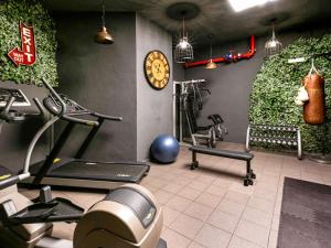 巴塞罗那诺富特巴塞罗那城市酒店的健身房设有健身器材和墙上的时钟