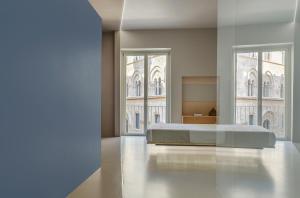 特拉帕尼Fiveplace Design Suites & Apartments的一间卧室设有一张床和两个大窗户