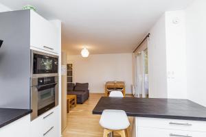沙朗通勒蓬Large apartment near Bois de Vincennes的一间带白色橱柜的厨房和一间客厅
