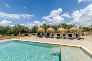 科斯提克斯Agroturismo Cal Tio 3 YourHouse的一个带椅子和茅草伞的游泳池的度假酒店