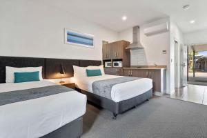 洛坎普顿Quality Resort Parkhurst的一间带两张床的卧室和一间厨房