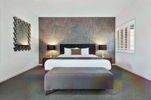 洛坎普顿Quality Resort Parkhurst的一间卧室配有一张大床和一个大搁脚凳