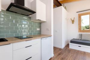科斯提克斯Agroturismo Cal Tio 3 YourHouse的厨房配有白色橱柜,墙上铺有绿色瓷砖。