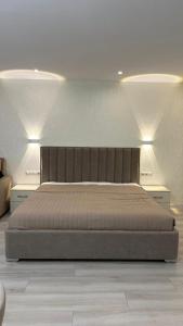撒马尔罕Samarkand Central Apartments的卧室内的一张大床,带两个灯