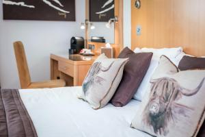 阿维莫尔High Range Lodge Hotel的一间卧室配有一张带枕头的床和一张书桌